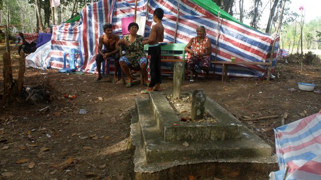 Warga berada di depan tenda pengungsian di dalam hutan Desa Sungai Rambai, Kelurahan Mekar Jaya, Kabupaten Sintang, Kalimantan Barat, Rabu (17/11/2021).  ANTARA FOTO/Jessica Helena Wuysang