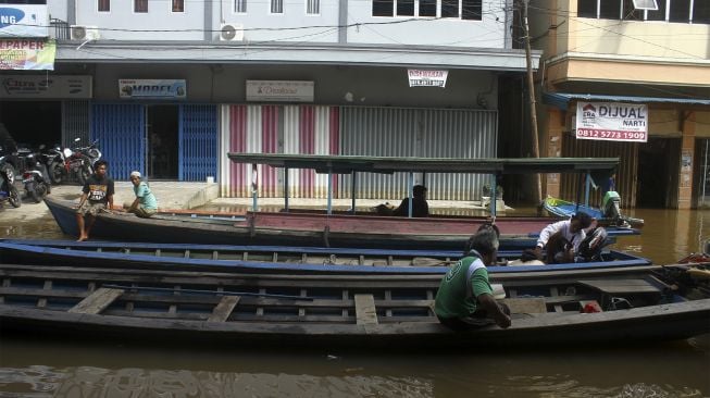 Sejumlah penjaja ojek perahu cepat bersandar di jalanan di Pasar Sungai Durian yang dilanda banjir di Sintang, Kalimantan Barat, Kamis (18/11/2021). [ANTARA FOTO/Jessica Helena Wuysang]