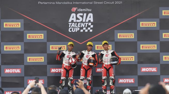 Pembalap IATC Furusato (tengah), Daniel Sharil (kiri) dan Gun Mie (kanan) berpose saat naik podium balapan hari pertama Idemitsu Asia Talent Cup (IATC) atau MotoGP Junior di Pertamina Mandalika International Street Circuit di KEK Mandalika, Desa Kuta, Kecamatan Pujut, Praya, Lombok Tengah, NTB, Jumat (19/11/2021). [ANTARA FOTO/Ahmad Subaidi]