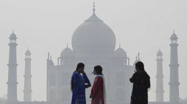 Ilustrasi: Warga mengunjungi kompleks Mehtab Bagh di belakang Taj Mahal di Agra, India, pada (16/11/2021). [SAJJAD HUSSAIN / AFP]