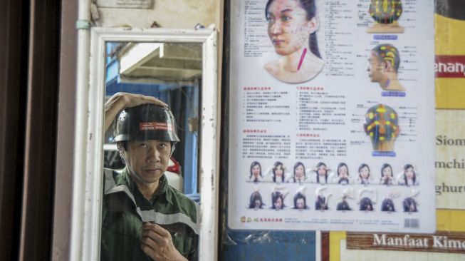 Seorang praktisi kesehatan Simon Sanjaya memakai helm terapi anti ngantuk di Andir, Bandung, Jawa Barat, Jumat (19/11/2021). [ANTARA FOTO/Raisan Al Farisi]