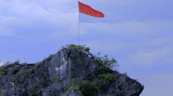 Bendera Merah Putih berkibar di salah satu pulau kecil yang berada di dekat Kampung Merah Putih di Desa Oeseli, Kabupaten Rote Ndao, NTT, Jumat (19/11/2021). [ANTARA FOTO/Kornelis Kaha]