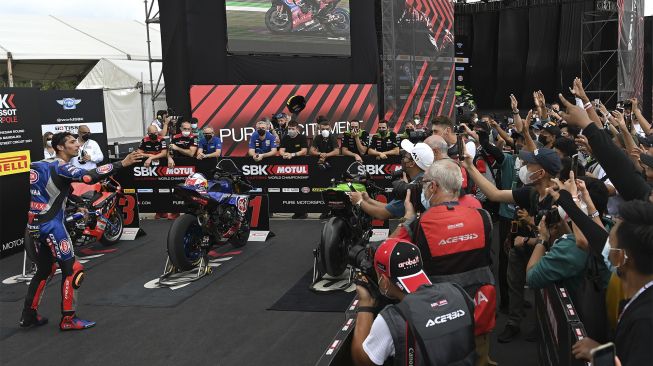 Pembalap Pata Yamaha With Brixx WorldSBK Toprak Razgatlioglu melemparkan topi kepada para penggemarnya usai meraih trofi SBK Tissot Superpole pada sesi kualifikasi WSBK Indonesia 2021 di Pertamina Mandalika International Street Circuit, Lombok Tengah, Nusa Tenggara Barat, Sabtu (20/11/2021). [ANTARA FOTO/Andika Wahyu]