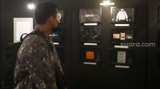 Sejumlah pengunjung melihat foto-foto yang ditampilkan pada pameran foto 'Anglocita' di Depok, Jawa Barat, Minggu (21/11/2021). [Suara.com/Alfian Winanto]