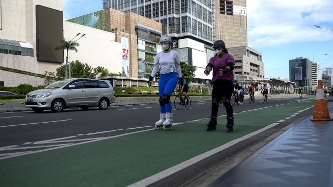 Warga bersepatu roda melintas di kawasan Bundaran Hotel Indonesia saat pemberlakuan PPKM level 1 di Jakarta, Minggu (21/11/21).  ANTARA FOTO/M Risyal Hidayat