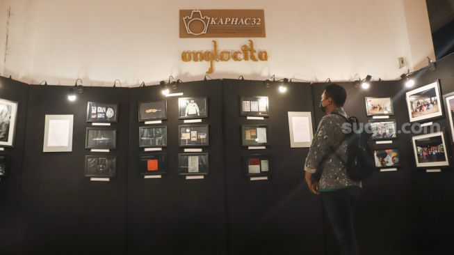 Sejumlah pengunjung melihat foto-foto yang ditampilkan pada pameran foto 'Anglocita' di Depok, Jawa Barat, Minggu (21/11/2021). [Suara.com/Alfian Winanto]