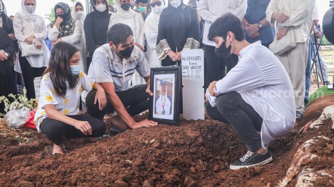 Keluarga berdoa diatas pusara mantan Atlet Bulutangkis Hj. Verawaty Fajrin usai dimakamkan di TPU Tanah Kusir, Jakarta Selatan, Minggu (21/11/2021). [Suara.com/Alfian Winanto]