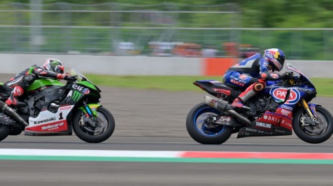 Pebalap Yamaha Toprak Razgatlioglu saat menyalip pebalap Kawasaki Jonathan Rea di race 1 WSBK Mandalika, Minggu (21/11/2021). (foto: AFP)