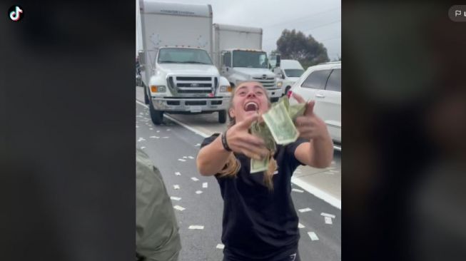 Pintu truk baja terbuka, uang kertas ribuan dolar berhamburan di California. (TikTok/@demibagby)