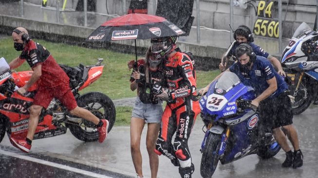 Pembalap tim Aruba.it Racing - Ducati WSBK Scott Redding (tengah) berjalan kembali menuju paddock dari grid start jelang balapan kedua (race 2) WSBK seri Indonesia saat hujan deras di Pertamina Mandalika International Street Circuit di KEK Mandalika, Desa Kuta, Kecamatan Pujut, Praya, Lombok Tengah, NTB, Minggu (21/11/2021). ANTARA FOTO/Ahmad Subaidi