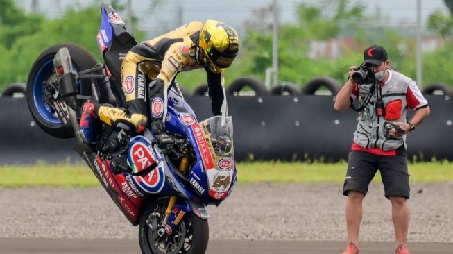 Aksi pebalap Yamaha, Toprak Razgatlioglu usai mengunci gelar juara dunia World Superbike (WSBK) 2021 di Sirkuit Mandalika, Lombok Tengah, NTB, Minggu (21/11/2021). [BAY ISMOYO / AFP]