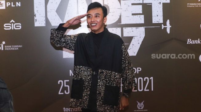 Aktor dan Komika Fajar Nugraha berpose didepan kamera saat gala premiere film 'Kadet 1947' di Senayan, Jakarta Selatan, Senin (22/11/2021). [Suara.com/Alfian Winanto]