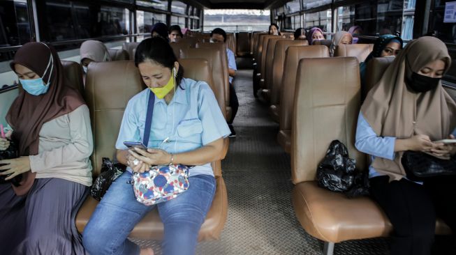 Sejumlah karyawan duduk di bus yang akan mengantar mereka pulang saat jam pulang kerja, di Kota Tangerang, Banten, Senin (22/11/2021).  ANTARA FOTO/Fauzan
