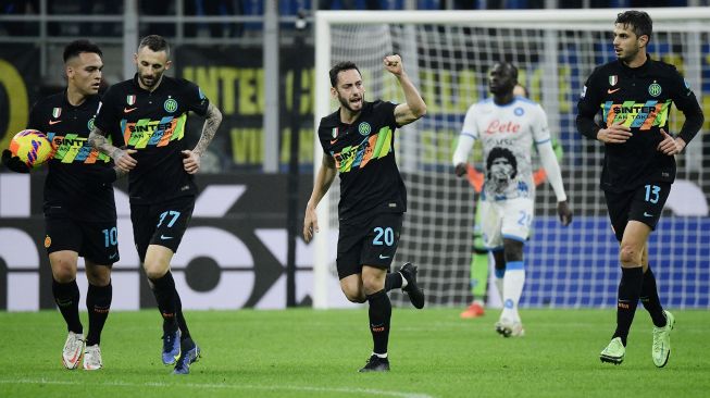 Gelandang Inter Milan Hakan Calhanoglu (tengah) merayakan usai mencetak gol pertama timnya selama pertandingan sepak bola Serie A Italia antara Inter melawan Napoli,  di Stadion Giuseppe Meazza, Milan, Itlia, Senin (22/11) dini hari WIB. Filippo MONTEFORTE / AFP