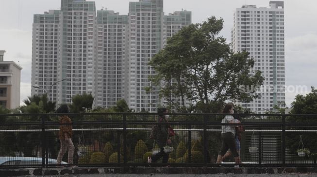 Pekerja berjalan menuju Halte Transjakarta Tosari saat jam pulang kerja di Jakarta, Selasa (23/11/2021). [Suara.com/Angga Budhiyanto]