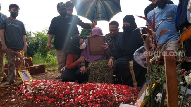 Sang nenek (berkerudung ungu) menangis di pemakaman Vanessa Angel di Taman Makam Malaka Jakarta Selatan, Senin (22/11/2021). [Yuliani/Suara.com]