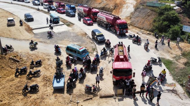 Sejumlah kendaraan terhenti dan tidak bisa melintas akibat aksi warga yang memblokir jalan di Kecamatan Kasilampe, Kendari, Sulawesi Tenggara, Selasa (23/11/2021).  ANTARA FOTO/Jojon