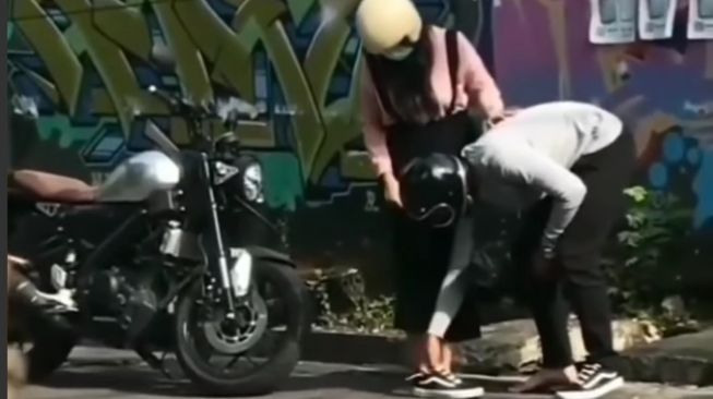 Pemotor pria merelakan sepatu untuk pasangannya yang sandalnya jebol (Instagram)