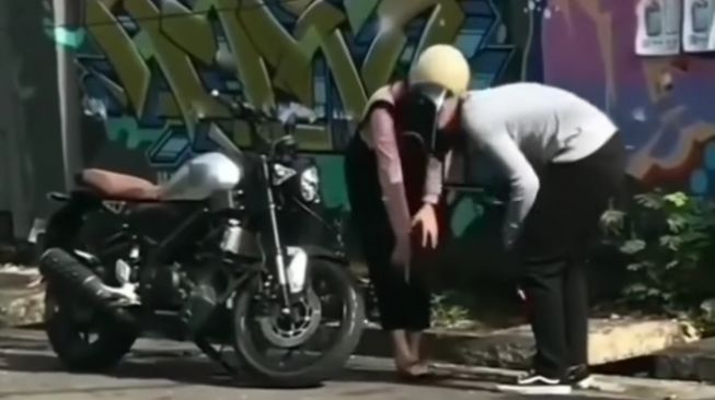 Pemotor pria merelakan sepatu untuk pasangannya yang sandalnya jebol (Instagram)