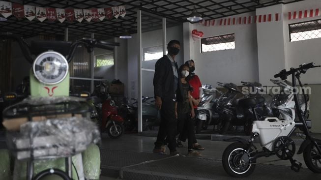 Calon pembeli melihat kendaraan listrik di salah satu dealer kendaraan listrik di Jakarta, Rabu (24/11/2021). [Suara.com/Angga Budhiyanto]