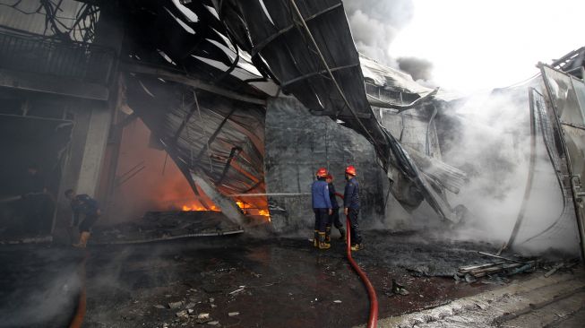 Petugas pemadam kebakaran berusaha memadamkan api yang membakar pabrik palet plastik di kawasan Desa Randegan, Tanggulangin, Sidoarjo, Jawa Timur, Rabu (24/11/2021).