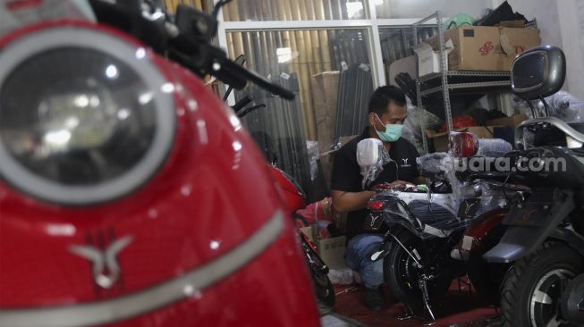 Teknisi memeriksa kendaraan listrik di salah satu dealer kendaraan listrik di Jakarta, Rabu (24/11/2021). [Suara.com/Angga Budhiyanto]