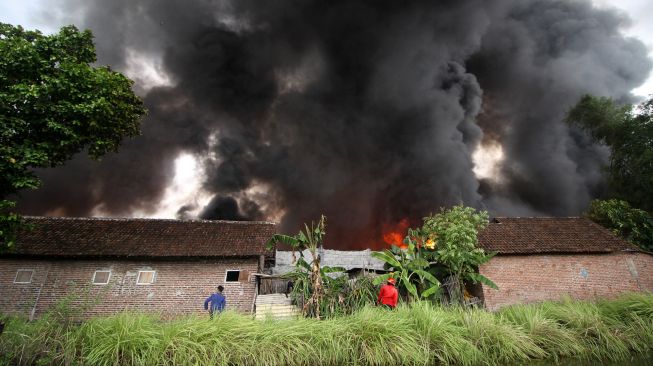 Asap membubung ke langit dari lokasi terbakarnya pabrik palet plastik di kawasan Desa Randegan, Tanggulangin, Sidoarjo, Jawa Timur, Rabu (24/11/2021). ANTARA FOTO/Umarul Faruq