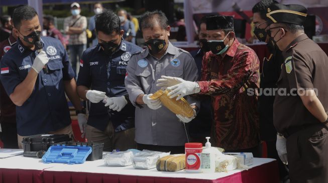 Petugas kepolisian bersama anggota BNNP DKI Jakarta melakukan uji labfor barang bukti narkotika saat konferensi pers hasil Operasi Nila Jaya 2021 dan pemusnahan barang bukti di Mapolda Metro Jaya, Jakarta, Kamis (25/11/2021). [Suara.com/Angga Budhiyanto]