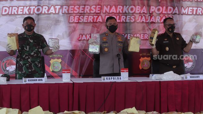 Kapolda Metro Jaya Irjen Fadil Imran (tengah) didampingi Kasdam Jaya Brigjen TNI Bobby Rinal Makmun (kiri) dan Wakajati DKI Jakarta Bambang Bachtiar (kanan) menunjukkan barang bukti narkotika saat konferensi pers hasil Operasi Nila Jaya 2021 dan pemusnahan barang bukti di Mapolda Metro Jaya, Jakarta, Kamis (25/11/2021). [Suara.com/Angga Budhiyanto]