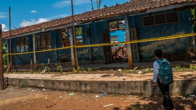 Seorang murid melihat atap gedung sekolah yang ambruk di SMP Negeri 1 Cibeber, Lebak, Banten, Kamis (25/11/2021).  ANTARA FOTO/Muhammad Bagus Khoirunas