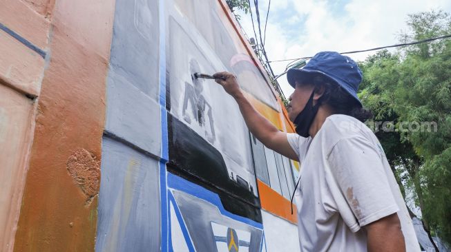 Warga menyelesaikan pembuatan mural dengan tema Jakarta di Kebayoran Lama, Jakarta Selatan, Jumat (26/11/2021). [Suara.com/Alfian Winanto]