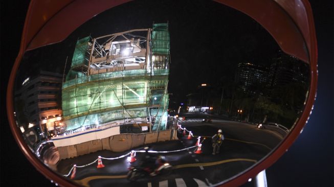 Refleksi petugas saat mempersiapkan relokasi Menara Tugu Jam Thamrin di Jakarta, Jumat (26/11/2021). [ANTARA FOTO/Wahyu Putro A]