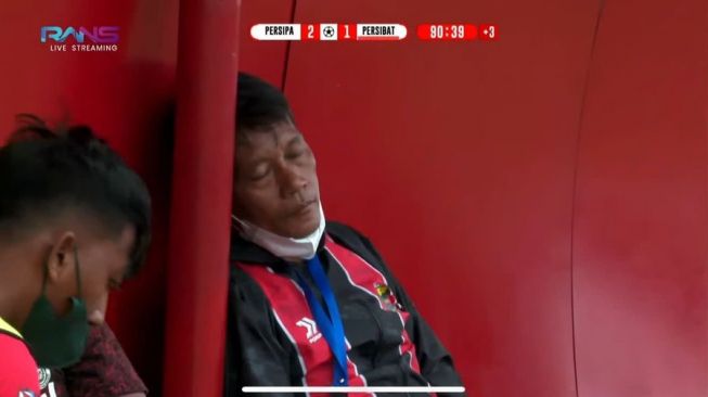 Pelatih Persibat Batang, Puji Handoko tertangkap kamera tengah tertidur di bench pemain cadangan. [Twitter @mafiabola]