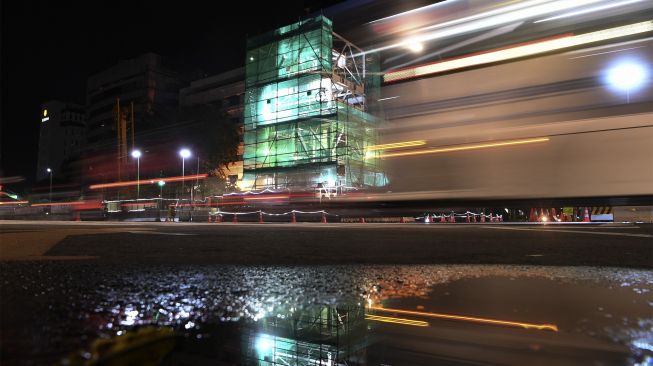 Pengendara melintasi Menara Tugu Jam Thamrin yang akan direlokasi di Jakarta, Jumat (26/11/2021). [ANTARA FOTO/Wahyu Putro A]