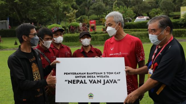 Gubernur Jawa Tengah, Ganjar Pranowo menyerahkan bantuan cat untuk warga di nepal van java. [Dok Pemprov Jateng]