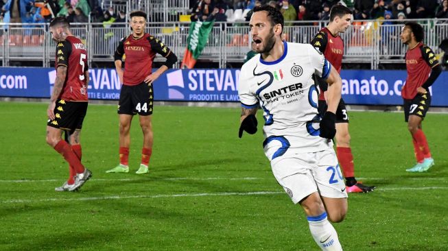 Gelandang Inter Milan asal Turki Hakan Calhanoglu merayakan golnya dengan rekan satu timnya setelah mencetak gol selama pertandingan sepak bola Serie A Italia Venezia melawan Inter Milan Stadion Pier Luigi Penzo, Minggu (28/11/2021) dini hari WIB. Andrea PATTARO / AFP
