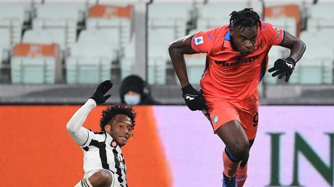 Gelandang Juventus Juan Cuadrado (kiri) berebut bola dengan penyerang Atalanta Duvan Zapata selama pertandingan sepak bola Serie A Italia Juventus melawan Atalanta di Stadion Allianz, Turin, Sabtu (27/11/2021). Isabella BONOTTO / AFP