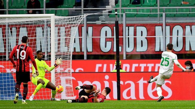 Pemain depan Sassuolo Domenico Berardi (kanan) menembak dan mencetak gol selama pertandingan sepak bola Serie A Italia AC Milan melawan Sassuolo di San Siro, Milan, Minggu (28/11/2021) malam WIB.
Isabella BONOTTO / AFP