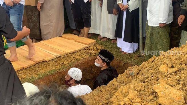 Alvin Faiz est descendu sur la tombe lors des funérailles de sa sœur, Ameer Azzikra au pensionnat islamique Az Zikra, Gunung Sindur, Bogor, lundi (29/11/2021). [Adiyoga Priyambodo/Suara.com]