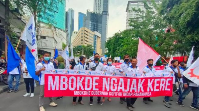 Aksi buruh di Surabaya digelar di depan Gedung Negara Grahadi Surabaya menuntut upah minimum pada Senin (29/11/2021). [Suara.com/Dimas Angga]