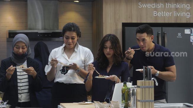 Marketing Head Electrolux Indonesia Peggy Anastasia (kedua kiri) bersama dengan pasangan selebriti Andrew White (kanan) dan Nana Mirdad (kedua kanan) mencicipi masakan yang dimasak oleh Chef Yuda Bustara selama demo masak 'plant-based' menggunakan produk dapur UltimateTaste dari Electrolux di The Dharmawangsa, Jakarta, Selasa (30/11/2021). [Suara.com/Angga Budhiyanto]