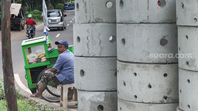 Warga beraktivitas di dekat buis beton drainase vertikal di kawasan Manggarai, Jakarta Selatan, Selasa (30/11/2021). [Suara.com/Alfian Winanto] 