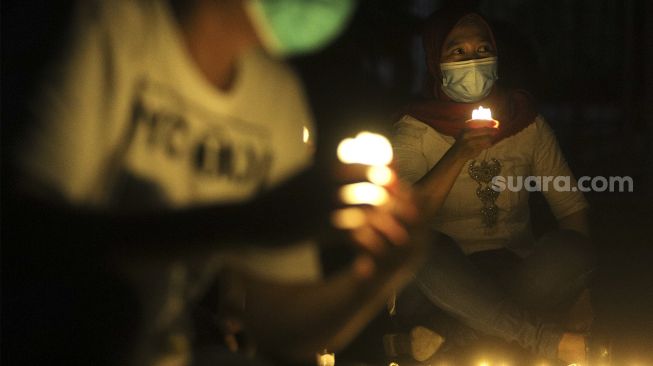 Relawan menyalakan lampu dalam malam renungan Hari AIDS Sedunia di Tanah Abang, Jakarta, Rabu (1/12/2021). [Suara.com/Angga Budhiyanto]