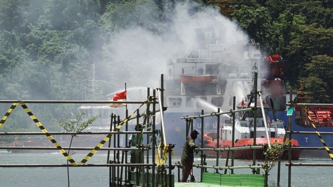 Tim SAR gabungan menggunakan Tugboat melakukan pemadaman kapal kargo Soemantri Brodjonegoro yang terbakar di perairan Teluk Penyu, Cilacap, Jawa Tengah, Rabu (1/12/2021).  ANTARA FOTO/Idhad Zakaria