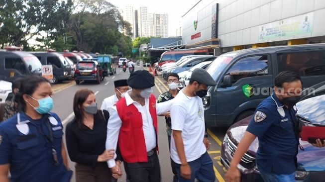 I Gede Ari Astina alias Jerinx SID mengenakan baju tahanan Kejari Jakarta Pusat resmi ditahan di Rutan Polda Metro Jaya. (Suara.com/Yaumal)