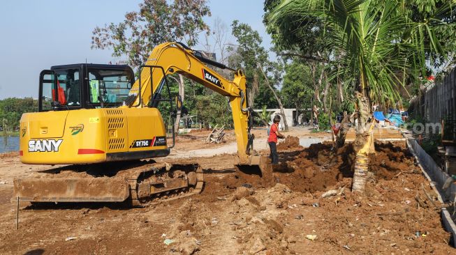 Pekerja mengoperasikan alat berat untuk menyelesaikan proyek revitalisasi Danau Sunter di Sunter, Jakarta Utara, Kamis (2/12/2021). [Suara.com/Alfian Winanto]