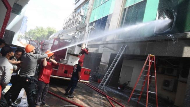 Petugas berusaha memadamkan kebakaran Gedung Cyber 1 Kuningan, Jakarta Selatan, Kamis (2/12/2021). [ANTARA/Akbar Nugroho Gumay]