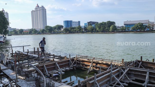 Pekerja menyelesaikan proyek revitalisasi Danau Sunter di Sunter, Jakarta Utara, Kamis (2/12/2021). [Suara.com/Alfian Winanto]