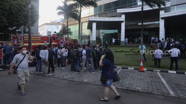 Sejumlah karyawan berada di luar Gedung Cyber 1, Jakarta, Kamis (2/12/2021). [Suara.com/Angga Budhiyanto]