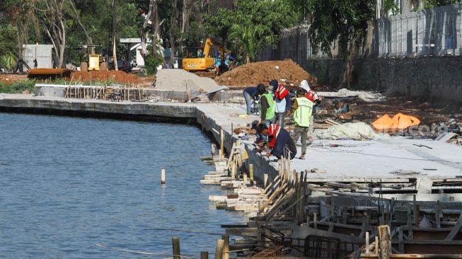 Pekerja menyelesaikan proyek revitalisasi Danau Sunter di Sunter, Jakarta Utara, Kamis (2/12/2021). [Suara.com/Alfian Winanto]